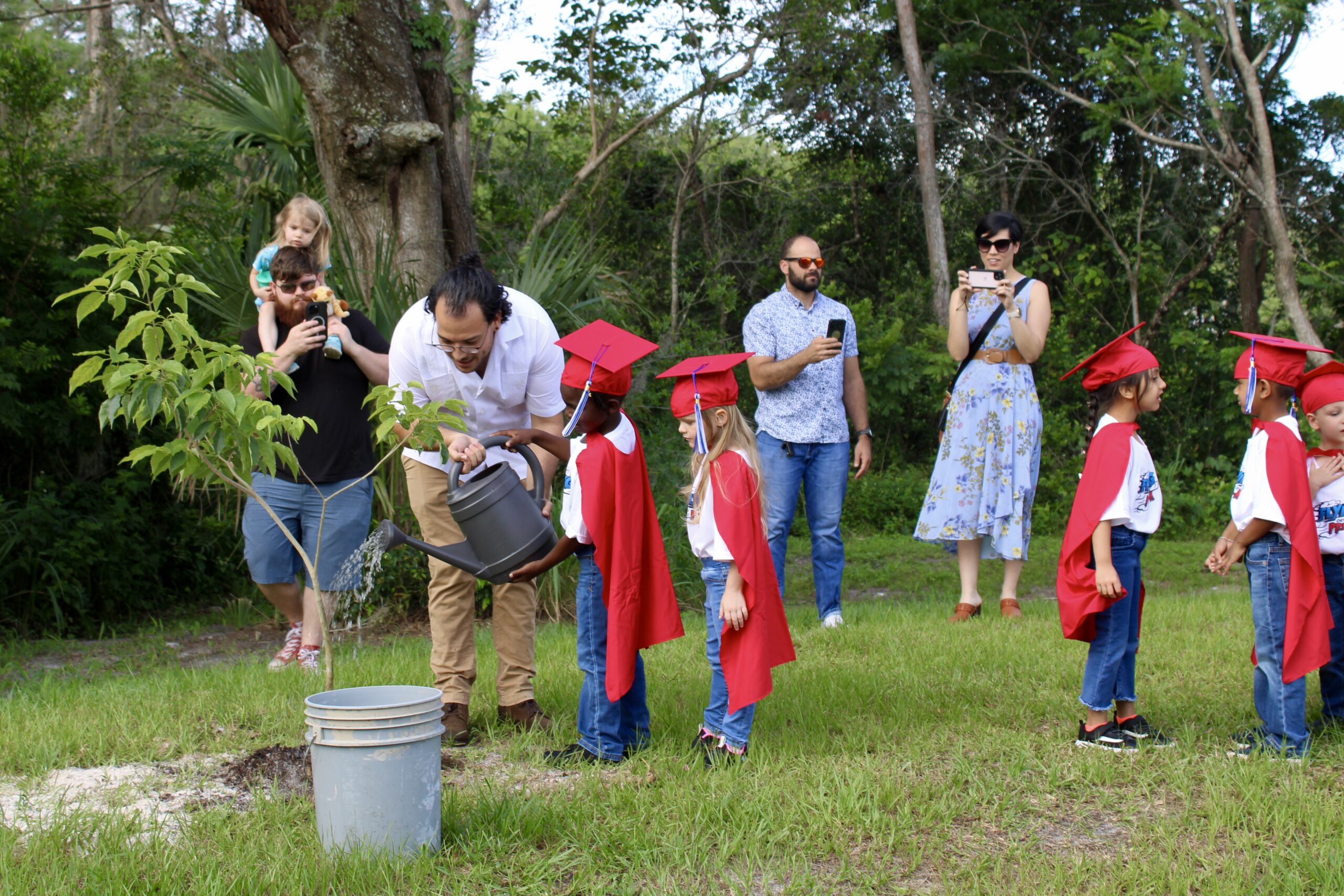 VPK Graduate watering the class learning tree, planted at their graduation ceremony